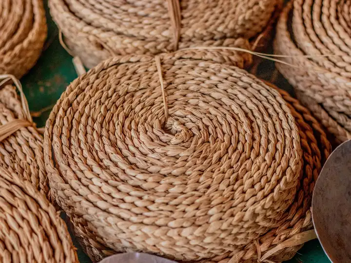 Des nattes rondes tressées en spirale, empilées les unes sur les autres.